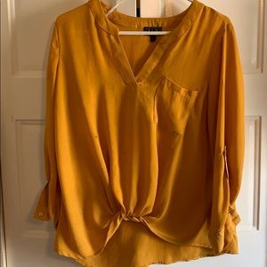 Mustard-yellow knotted shirt.